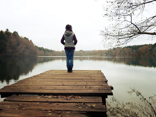 Une dame seule devant un lac